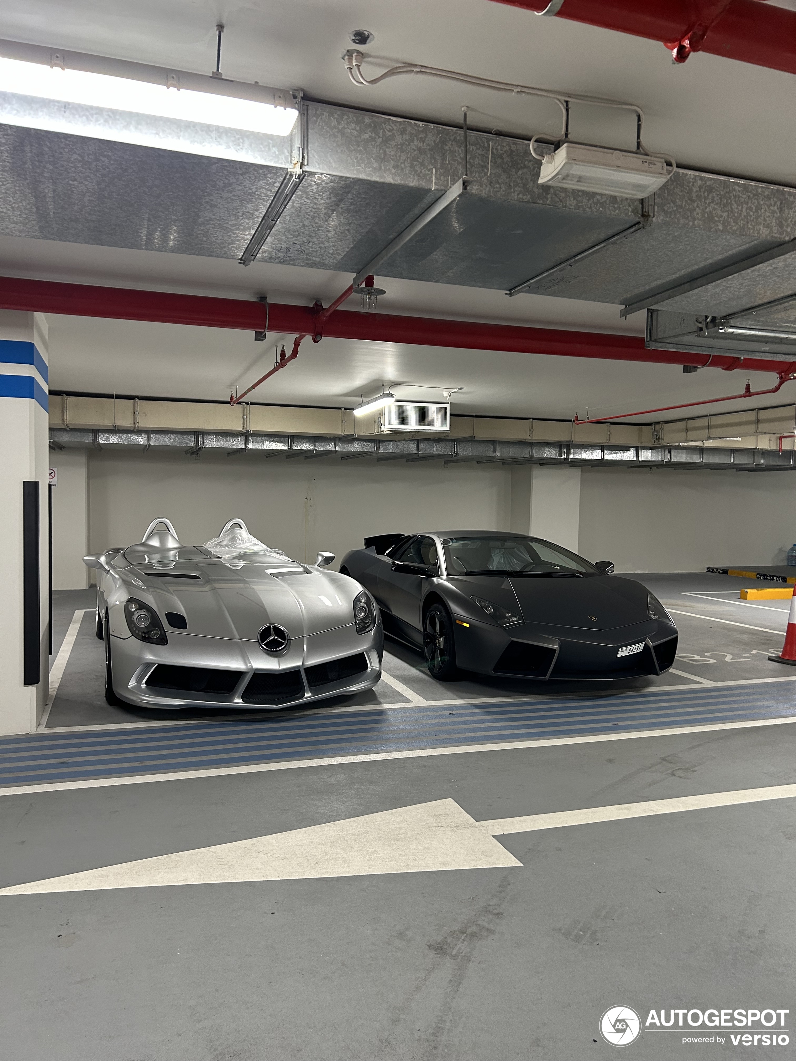 Two legendary cars are standing together in an underground garage in Dubai.